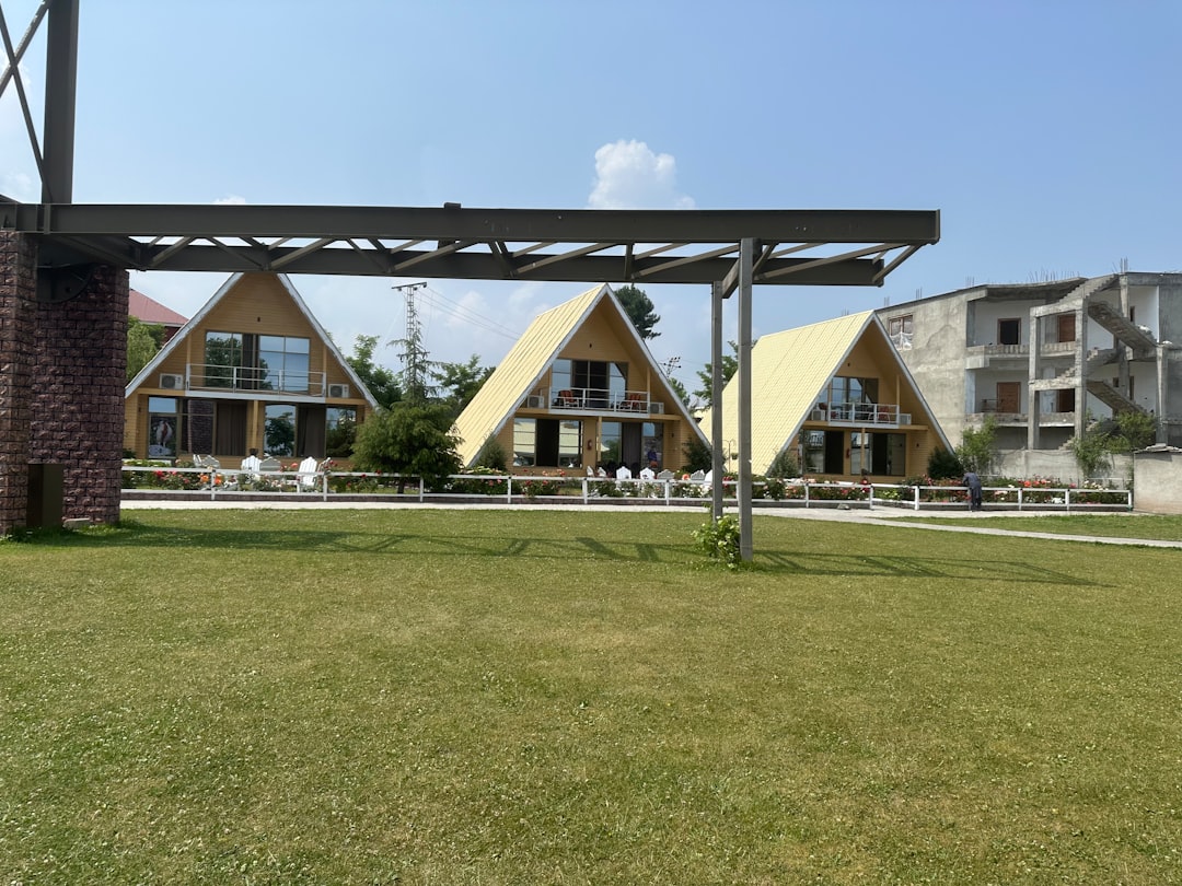 a row of houses sitting on top of a lush green field