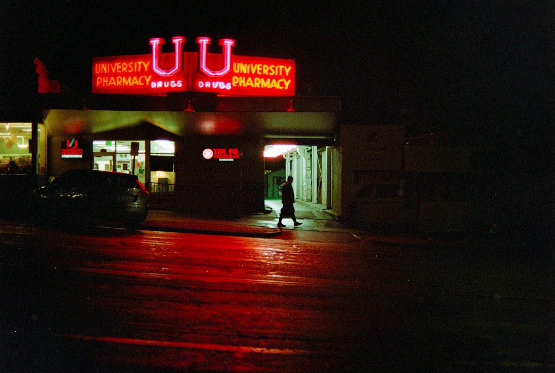 University pharmacy illuminated at night with red neon lights