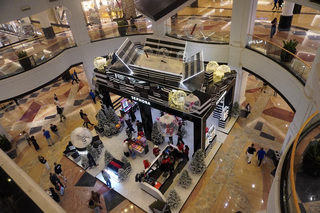 Busy shopping mall with people and displays.