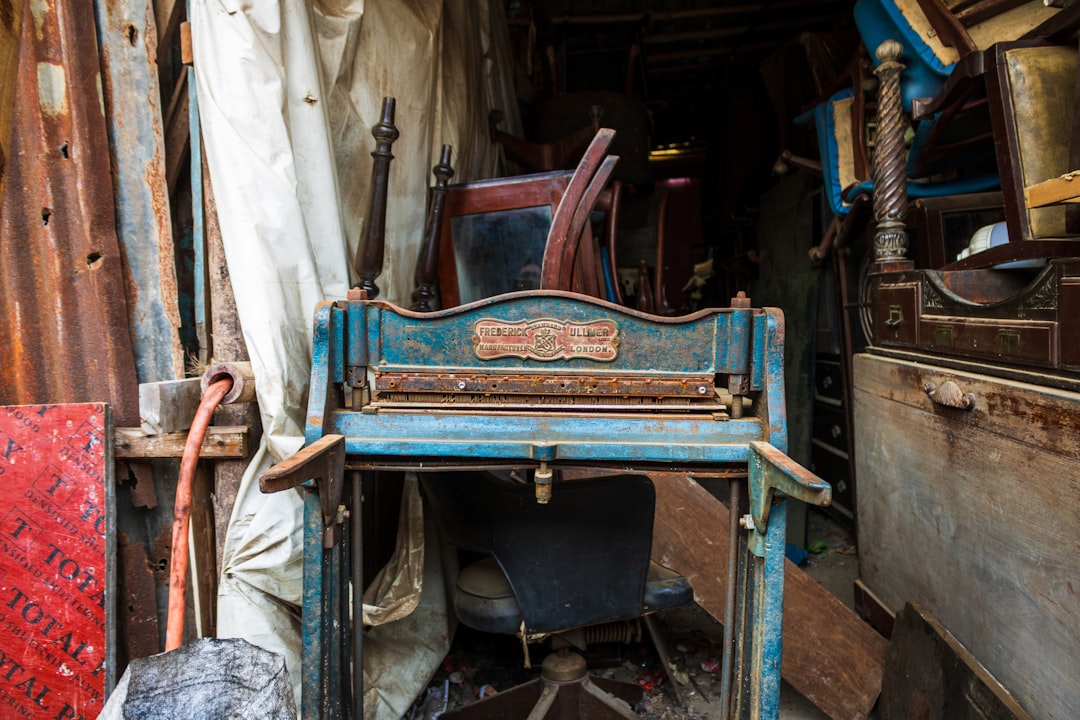 Antique blue printing press in cluttered workshop